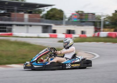 girl go kart racer driving around the fastest turn at Malaysia's largest and most challenging circuit, Morac Adventure Park, Langkawi, Malaysia. The only track to have a live LED timing board on track