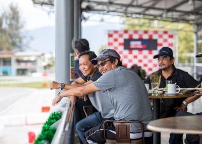 Enjoying a drink while sitting in the viewing area while go kart racers race at Morac Adventure Park, Langkawi, Malaysia
